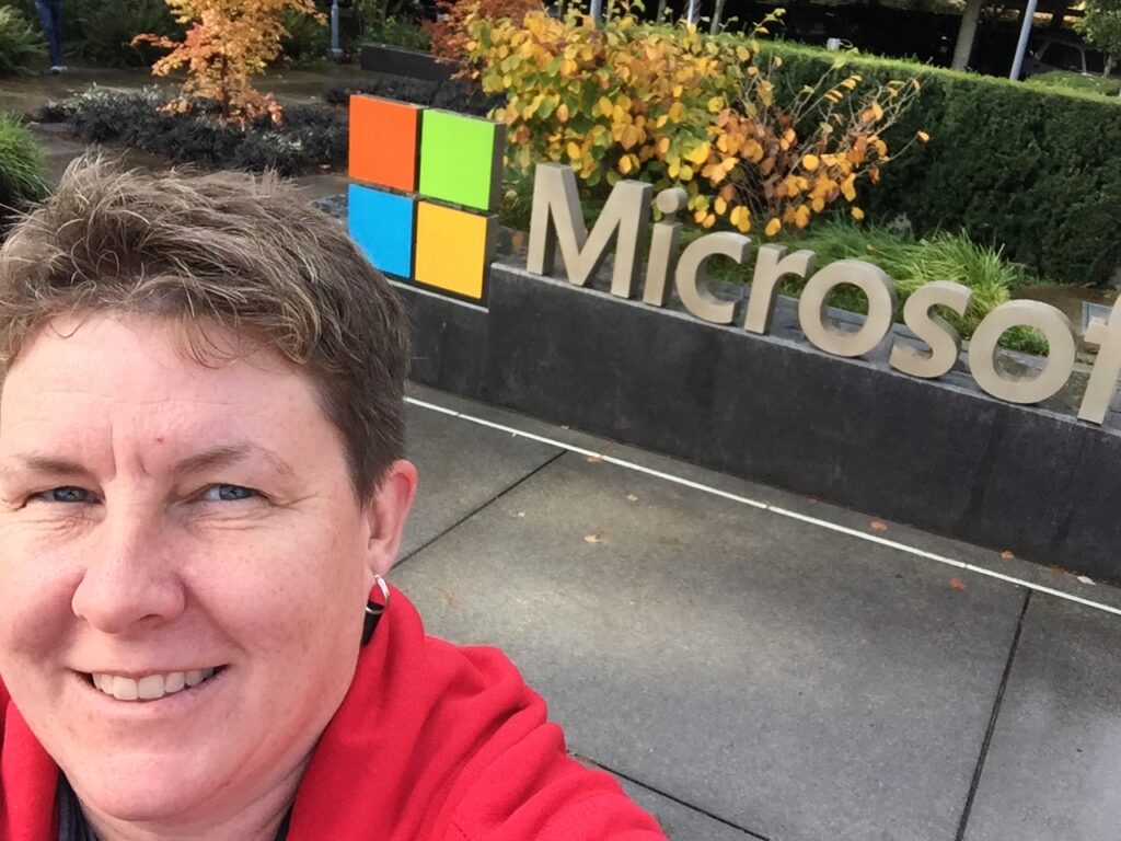 Selfie of me in front of Microsoft logo.