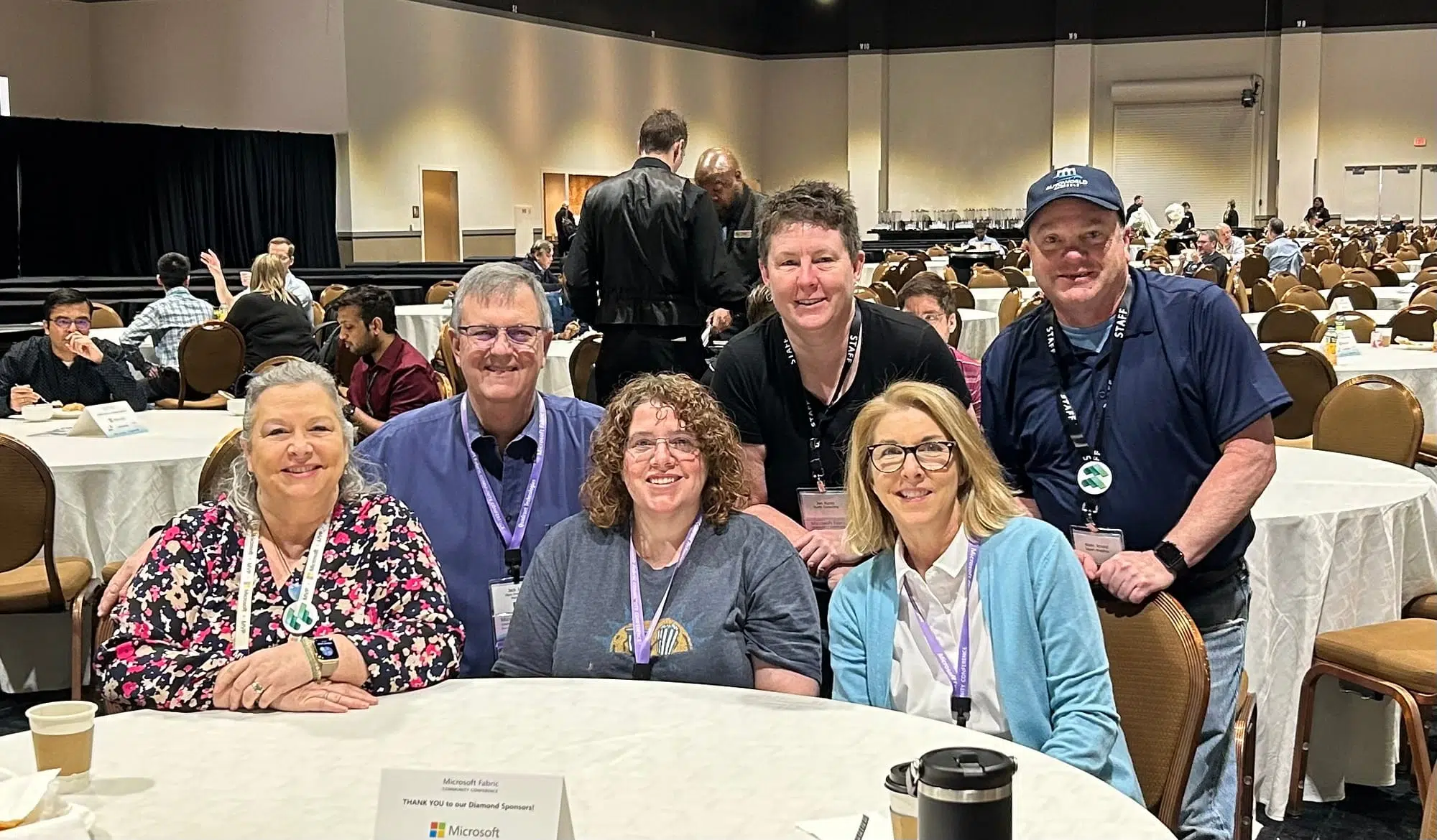 6 #SML friends posing around the conference dining tables. Left to right: Belinda Allen, with long grey hair tied back, wearing a floral print long sleeve shirt; Jack Irby with short grey hair and glasses in a blue button down shirt; Christina Lanham with brown curly hair and glasses, wearing a grey t-shirt; me with short brown hair in a black t-shirt; Sheila Hart with blonde hair and glasses, wearing a white shirt under a light blue cardigan; Kevin Arnold, wearing a blue baseball cap, wearing a dark blue golf shirt and blue jeans.