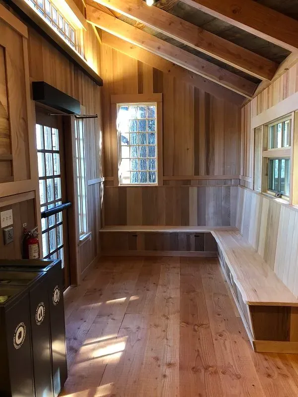 Interior of Microsoft treehouse meeting space with wooden walls, built-in bench seating, exposed beam ceiling, and natural light