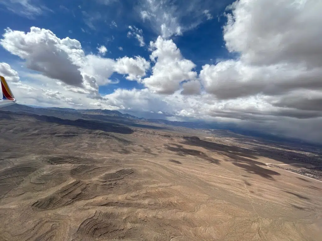 Aerial view of desert landscape with layered rock formations near Las Vegas, Southwest Airlines winglet visible.